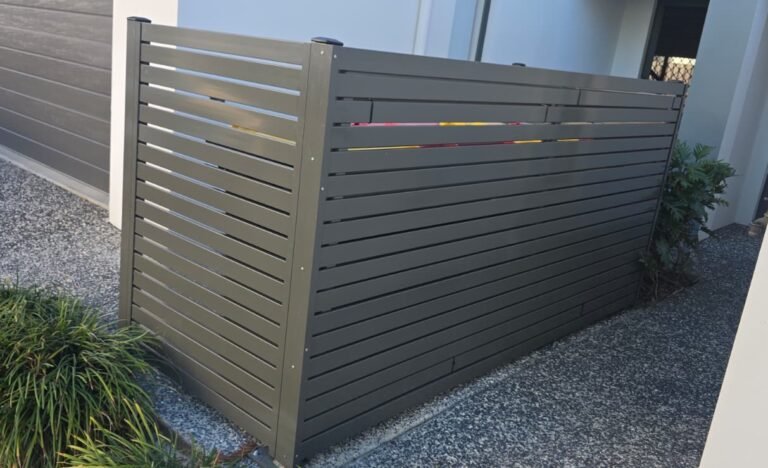 Horizontal slat bin enclosure in powder coated aluminium, Slate Grey, screening wheelie bins beside a modern home driveway, supplied by Accolade Fencing Deception Bay