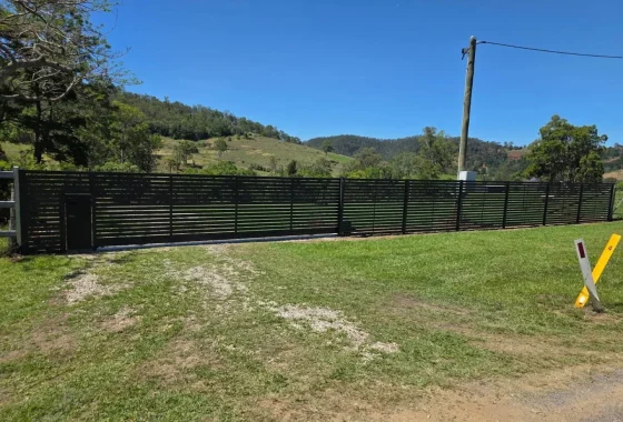 Horizontal slat sliding gate with pedestrian gate in black aluminium